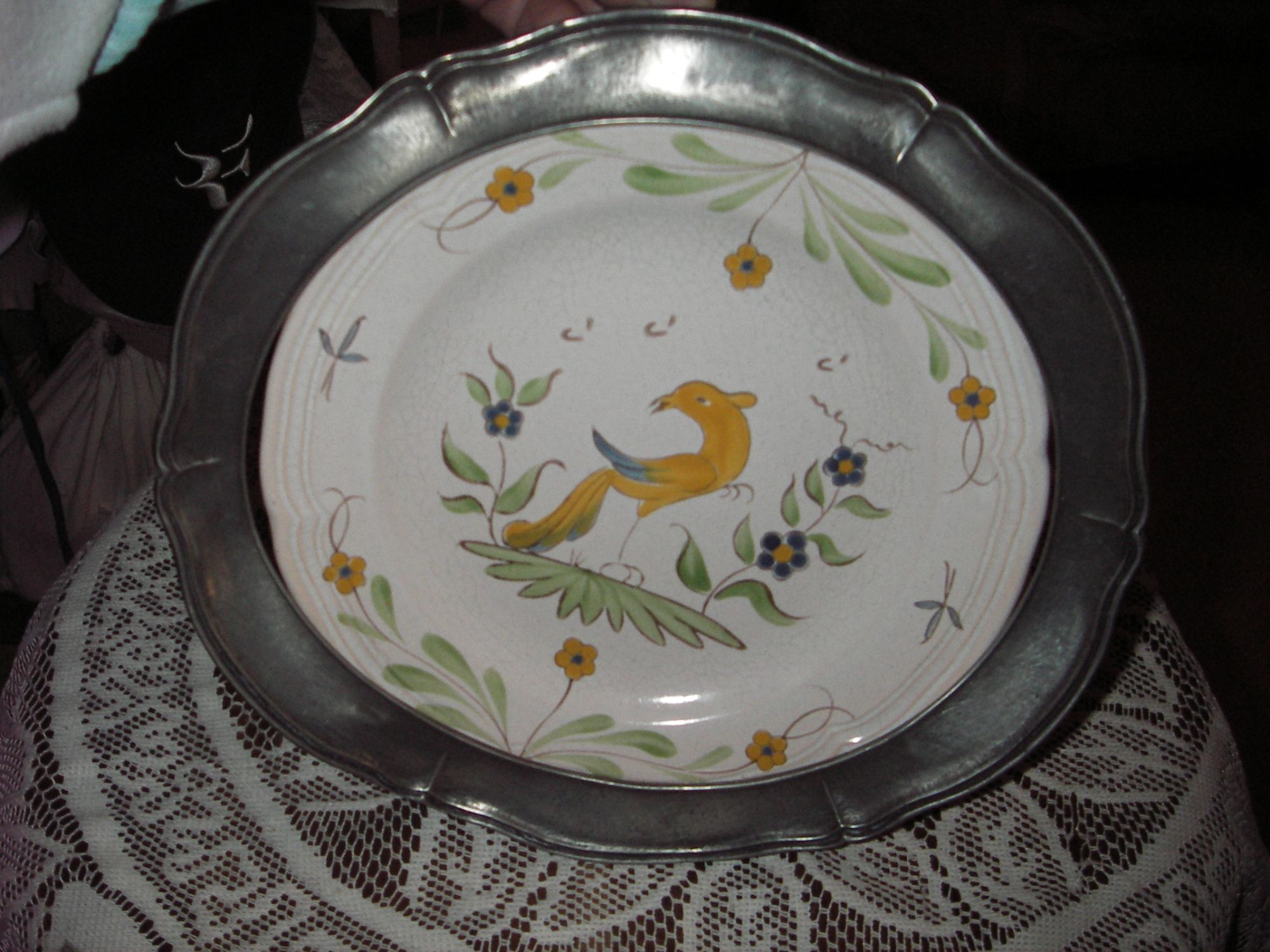 Assiette de collection en faïence de Pornic support cerclage ovale en forme de fleur en  étain poinçonné ,décor assiette :oiseau et petites fleurs sur fond blanc cassé . 