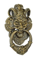 Un heurtoir de porte en fonte représentant un visage de diable - couleur bronze 