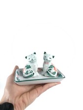 Salière et poivrière en forme de chat sur leur plateau en porcelaine