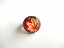 Bague ronde, au motif de feuille d'érable du Japon sur fond rouge bordeaux. 