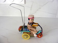 Petit garçon à tricycle jouets à remonter à clef qui foncionne très bien en tôle