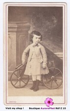 ENFANT DEVANT UN JOUET TRICYCLE CHEVAL, TOY HORSE, CDV LEBIEZ à ANGERS  -Z10