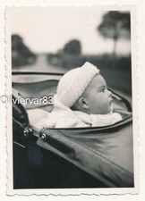 Vintage photo - baby poking head out of pram on a road, depth of field
