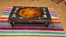 Table basse chinoise en bois laqué représentant l'affrontement deux dragons.