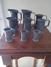 Série de 9 pots de mesure genre étain divers de 10 cm à 4 cm