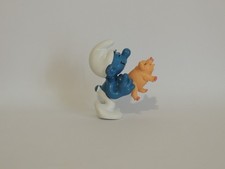 Schtroumpf avec petit cochon dans les mains