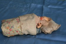 ancienne poupée miniature dans son couffin.