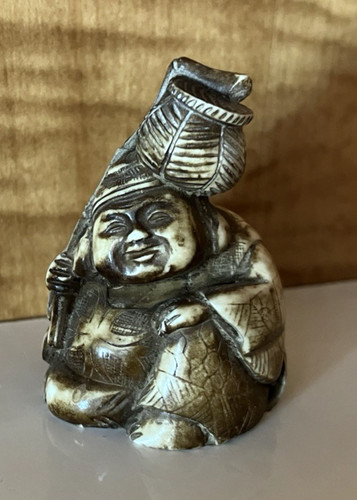 Carved resin man carrying - carved,