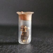 Minuscule tube a essai éprouvette contenant 9 pièces d'horlogerie ?