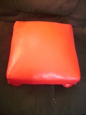 Repose-pieds en simili cuir rouge mesurant 29 cm X 29 cm X 15 cm