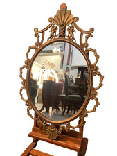 Miroir ovale en laiton doré, figures de chérubins et moulures