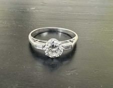 Bague De Fiançailles en Or Gris avec un Solitaire et Deux Baguette Diamants.