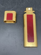 CARTIER: Petit vaporisateur en métal doré et laqué bordeaux.