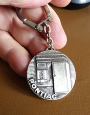 Ancien porte cle métal signé Drago Réfrigérateur Pontiac Arc de Triomphe Paris.