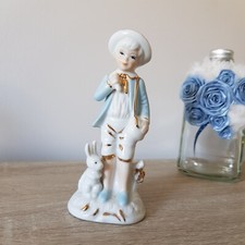 Délicate figurine en céramique avec dorure, jeune enfant accompagné d'un lapin.