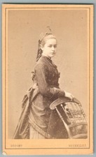 CDV 1870's Jeune fille robe à tournure jouant avec chaise Photo Dupont Bruxelles