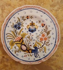Assiette en faïence signée Geo martel a décor de la corne d'abondance Desvres ?