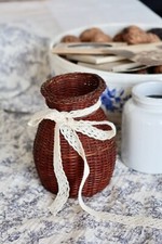 Petit vase vintage en osier foncé avec nœud en dentelle