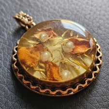 Médaillon ancien contenant des végétaux & perles sous résine monture laiton