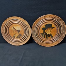 2 assiettes décoratives en bois à décor d'une femme et d'un homme - Signée - XXe
