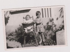 photo ancienne ?️ bébé en chaise haute et grand frère protecteur au jardin