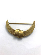 Broche en métal doré signé