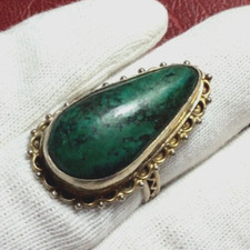 Silver ring with a green teardrop stone to identify