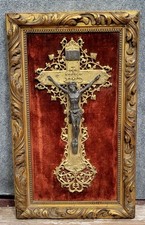 Crucifix ancien sur fond de velours pourpre dans un cadre en bois doré