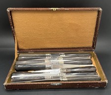 12 couteaux de table en écrin, manche corne, virole argent