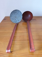 Une écumoire et une louche en métal émaillé rouge et gris moucheté années 50