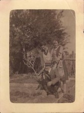 snapshot deux femmes et un homme chapeau barbe assis jardin arbre tablier 