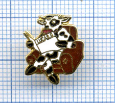 Petit Pin's TOSCA genre BD vache lisant journal Lucas G dans fauteuil cuir / Cow