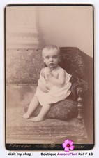 BÉBÉ EN POSE ASSIS SUR UN