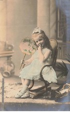 Fillette dans un rocking chair avec un doigt dans la bouche