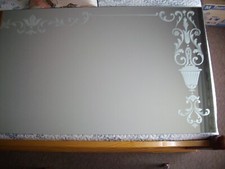 miroir mural argenté sans cadre décor floral dépoli sur les côtés et le haut.