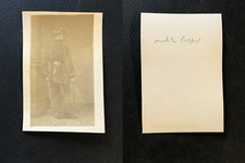 Homme en uniforme et manteau militaire, posant de dos appuyé sur son épée, 1870 