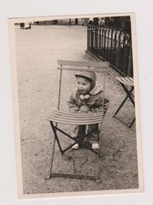 Photo ancienne ?️ Enfant joue derrière chaise dans parc calme vintage