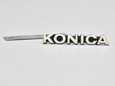 KONICA : LOGO EN MÉTAL ET EN RELIEF, AVEC AGRAFES ET CONTRE-PLAQUE