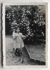 Fille jardin fleurs trottinette, robe,  france  - Photo vintage snapshot 1954