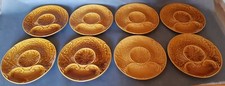 Un service de 8 assiettes à artichaut en faïence vernis de Gien. Ocre.