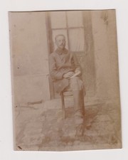 photo ancienne 🎞️ soldat prisonnier assis tenant cahier devant porte vitrée