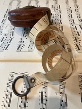 Mètre ruban ancien en cuir, tissu et laiton.