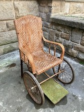 Fauteuil roulant pour handicapé datant d'environ 1900, en chêne et cannage