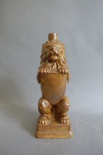 Bouteille zoomorphe en grès émaillé figurant un lion au blason signée