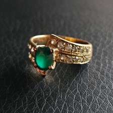 Bague pierre centrale verte ruban desaxés couverts de cristaux clair plaqué or