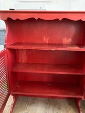 Je vends un meuble de rangement rouge en bois qui peut être repeint. 