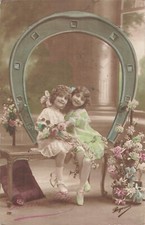 CP BONNE FETE PETITES FILLES ELEGANTES ASSISES SUR BANC SOUS FER A CHEVAL FLEURS