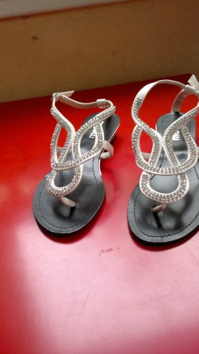 Sandales blanches entre doigts