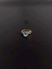 Je vend une bague or jaune et blanc avec une pierre topaze bleu..