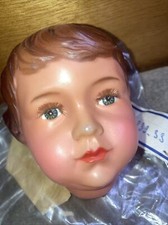 (L)  tête de poupée